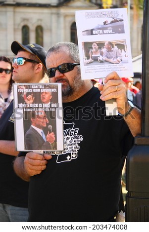 BRISBANE, AUSTRALIA - JULY 06 : Unidentified protester with anti liberal government posters at Bust The Budget Rally July 06, 2014 in Brisbane, Australia