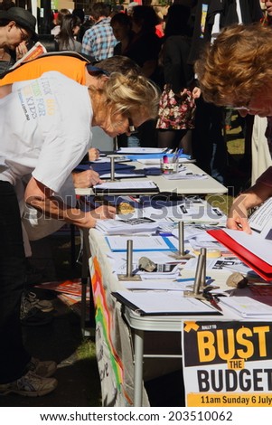 BRISBANE, AUSTRALIA - JULY 06 : Unidentified  older Australians signing budget petition at Bust The Budget anti liberal governement Rally July 06, 2014 in Brisbane, Australia
