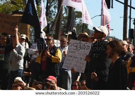 BRISBANE, AUSTRALIA - JULY 06 : Unidentified protesters with anti budget sign at Bust The Budget anti liberal government Rally July 06, 2014 in Brisbane, Australia