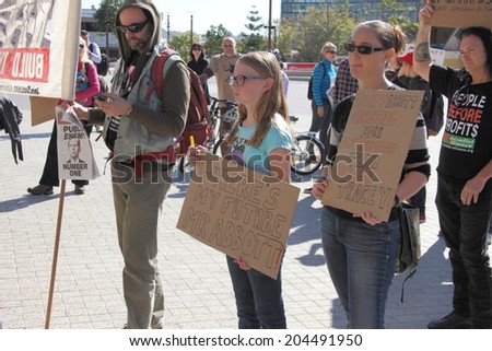 BRISBANE, AUSTRALIA - JULY 12 : Unidentified families of protesters with anti government signs outside Liberal National Party national conference July 12, 2014 in Brisbane, Australia