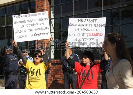 BRISBANE, AUSTRALIA - JULY 12 : Unidentified protesters with anti refugee policy signs outside Liberal National Party national conference July 12, 2014 in Brisbane, Australia