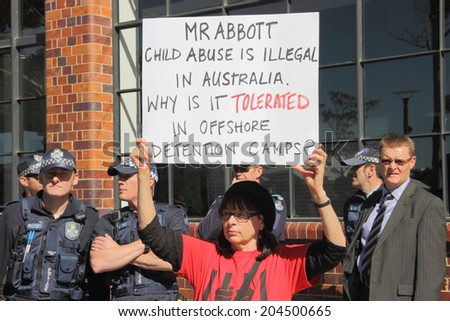 BRISBANE, AUSTRALIA - JULY 12 : Unidentified protester with anti refugee policy signs outside Liberal National Party national conference July 12, 2014 in Brisbane, Australia