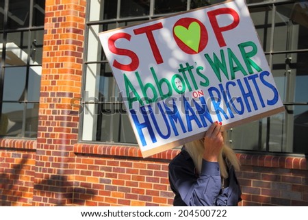 BRISBANE, AUSTRALIA - JULY 12 : Unidentified protester with anti refugee policy sign outside Liberal National Party national conference July 12, 2014 in Brisbane, Australia