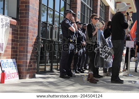 BRISBANE, AUSTRALIA - JULY 12 : Unidentified protesters in front of police cordon outside Liberal National Party national conference July 12, 2014 in Brisbane, Australia