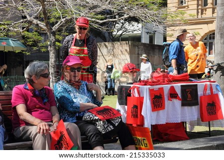 BRISBANE, AUSTRALIA - AUGUST 31: Unidentified protesters at anti Abbott merchandise stall at March Australia Rally August 31, 2014 in Brisbane, Australia