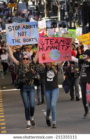 BRISBANE, AUSTRALIA - AUGUST 31: Unidentified protesters with anti Abbott Team Australia and refugee policy signs at March Australia Rally August 31, 2014 in Brisbane, Australia