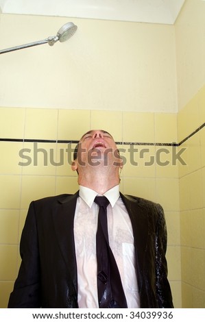 Business man drowning his sorrows with refreshing shower