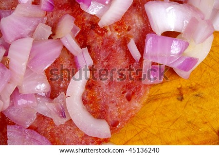 macro of grilled ham steak on wooden board with spanish onions