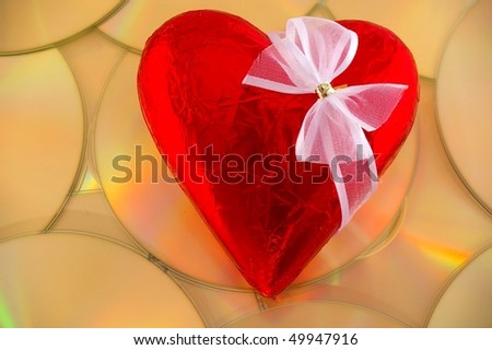 Valentine chocolate heart in red foil with white bow on music cds mixed tape concept