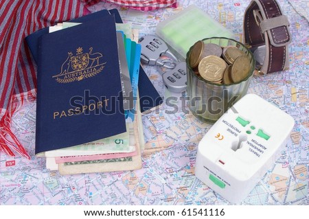 australian passport and holder with travel items on top of paris map