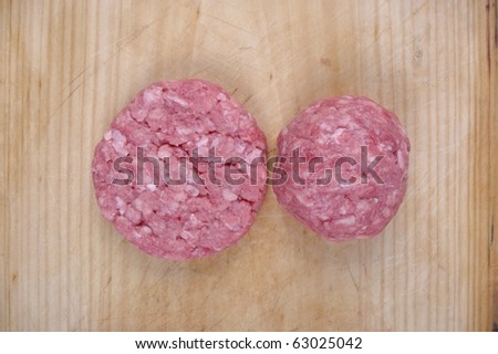 organic minced meat patty and rissole on wooden chopping board