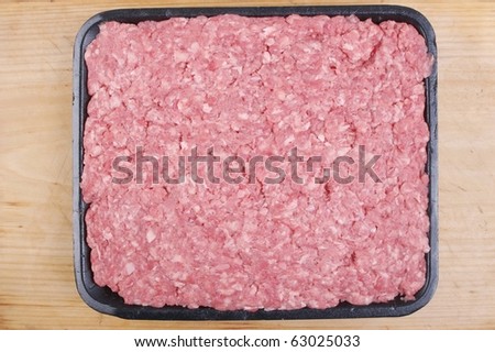 organic minced meat in tray on wooden chopping board