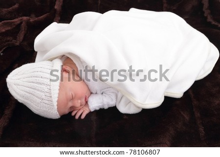 newborn infant baby on fur baby rug having nap time