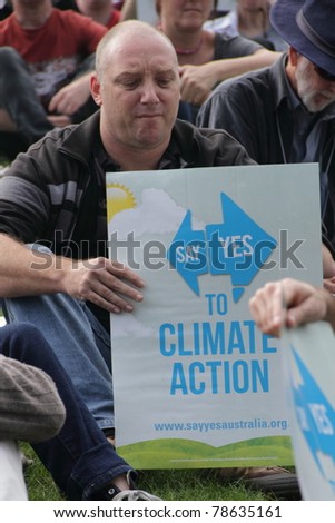 BRISBANE, AUSTRALIA - JUNE 6 : man with say Yes to climate action sign listening to rally speakers during World Environment Day say Yes protest 6, 2011 in Brisbane, Australia