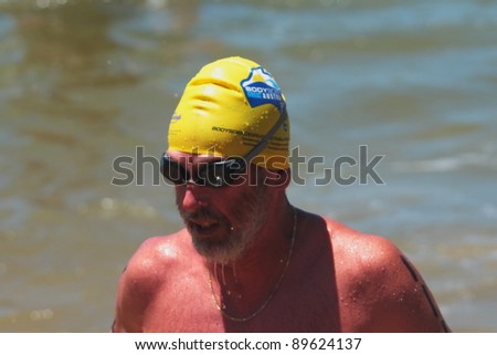 BRISBANE, AUSTRALIA  NOV 27 :Older unidentified man finishes the 5km open water swim called Great Australian Swim Series race November 27, 2011 in Brisbane, Australia