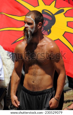 BRISBANE, AUSTRALIA - NOVEMBER 14: Unidentified protester in front of international indigenous flag during g20 aboriginal deaths in custody protest on November 14, 2014 in Brisbane, Australia