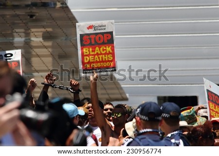 BRISBANE, AUSTRALIA - NOVEMBER 14: Unidentified aboriginal man holding protest sign protesting deaths in custody at g20 on November 14, 2014 in Brisbane, Australia