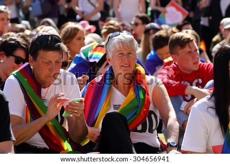 BRISBANE, AUSTRALIA - AUGUST 8 2015: Unidentified rally goer adorned with gay pride flags at Marriage Equality Rally August 8, 2015 in Brisbane, Australia