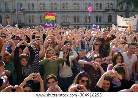 BRISBANE, AUSTRALIA - AUGUST 8 2015: Crowds making love heart hand sign at Marriage Equality Rally August 8, 2015 in Brisbane, Australia