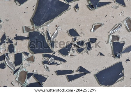 Broken mirror glass shards spread on the floor