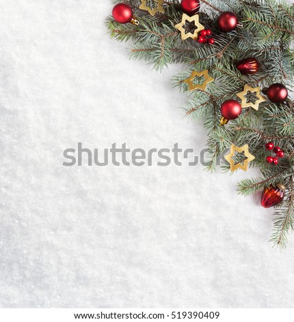 Fir branch with Christmas decorations on the background of natural snow.