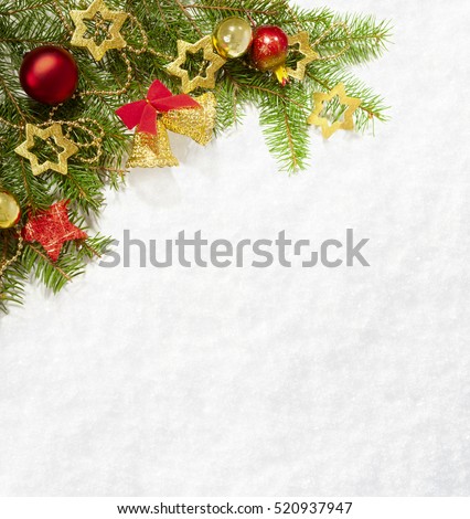 Fir branch with Christmas decorations on the background of natural snow.