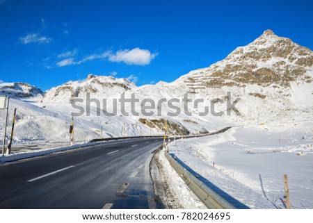 Mountain road in Swiss alps  at sunny winter day,  Julier Pass, Graubunden, Switzerland.  Julier Pass - mountain pass in Switzerland, in the Albula Range of the Alps.