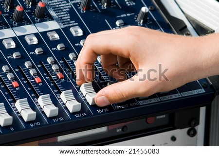 Human Hand using an audio mixer to tune the volume