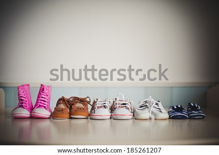 many children's shoes standing in a row on the table