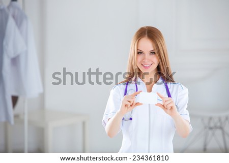 Medical doctor showing business card sign, blank with copy space for text or design. Woman medical professional