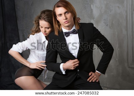 Portrait of young couple in love posing at studio dressed in classic clothes. Beauty and Fashion.