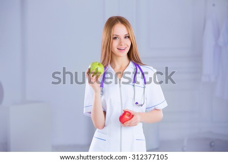 Doctor nutritionist. Confident doctor with apples on the medical background.