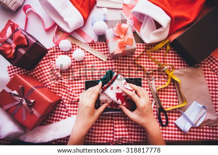 Hands of woman decorating Christmas gift box. Prepare gifts.