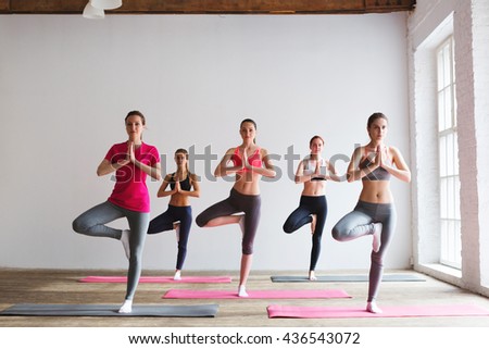 Group of women doing yoga in a fitness gym.