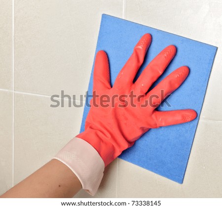 closeup of a cleaning glove and sponge on tiles