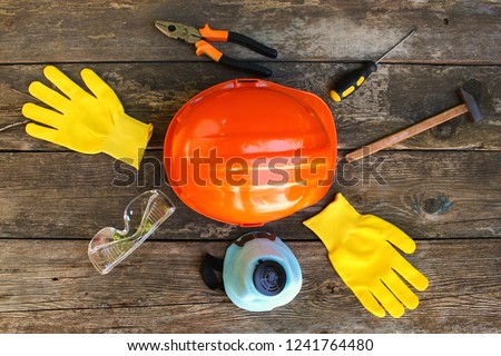 Construction tools and means of protection on an old wooden background. Top view. Flat lay.