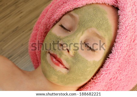 Beautiful girl with clay mask facial