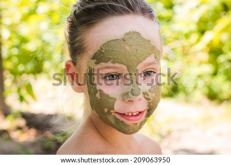 Close up of beautiful girl with facial clay mask
