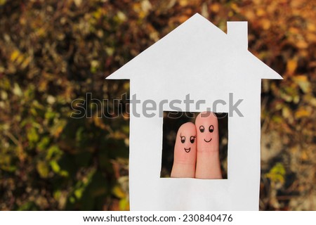 Finger art of a Happy couple. Family looking out of the window of the house out of paper.