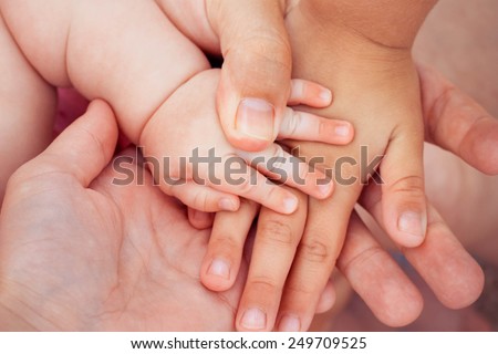 Four hands of the family. The concept of love, friendship, happiness in the family. Tinted image.Toned image.