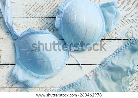 Feminine blue underclothes on white wooden background