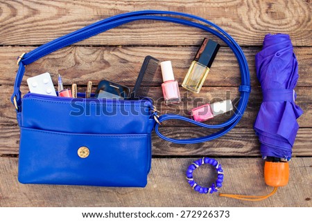 Blue women\'s purse. Things from open lady hand bag. Toned image.