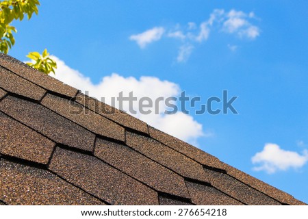 The roof of the house in the background of the sky