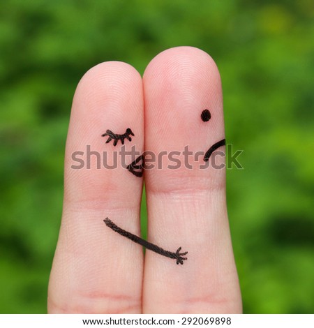 Finger art of couple. A woman kisses a man, she don\'t like him. The concept is not shared love.