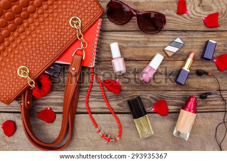 Things from open lady handbag. women\'s purse on wood background. Toned image.