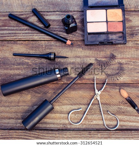 Cosmetics for eyes: pencil, mascara, eyeliner, false eyelashes and eye shadow. Toned image.