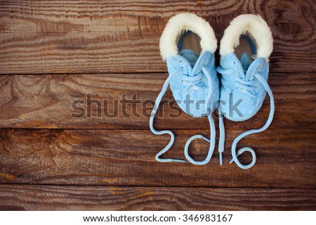 2016 year written laces of children\'s shoes on old wooden background. Toned image