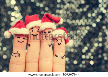 Finger art of friends celebrates Christmas. The concept of a group of people laughing in new year hats. Toned image.
