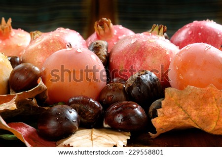 bouquet with autumn chestnuts, pomegranates, persimmons on a bed of leaves.