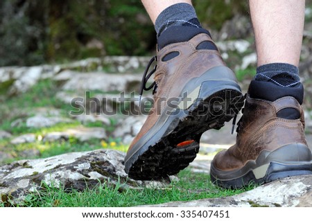 Walking on the rocks of a mountain trail with hiking boots